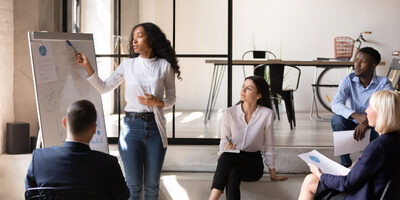 Women presenting to a group of professionals covering diversity, inclusion, culture and ethics